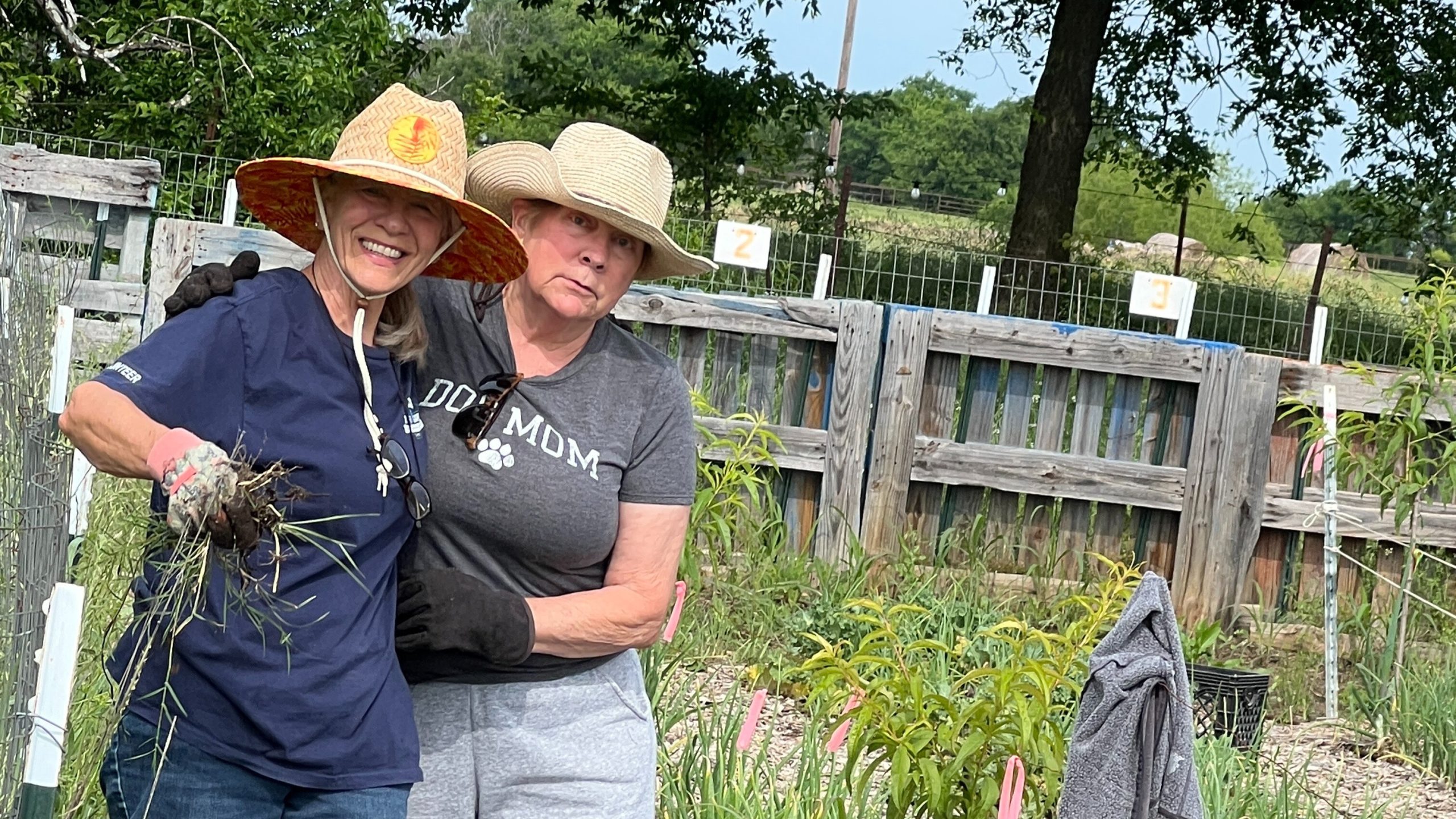 Two gardeners posing in a garden